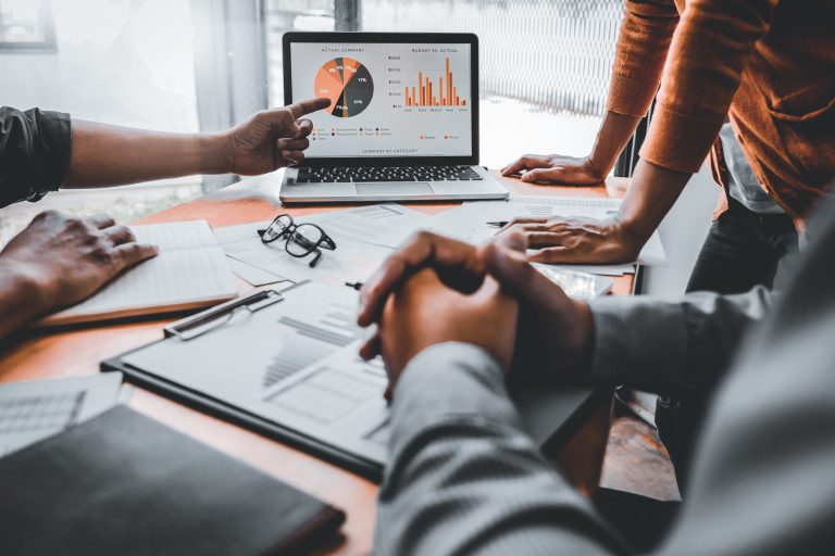 Møterom med engasjerte kolleger som diskuterer budsjett